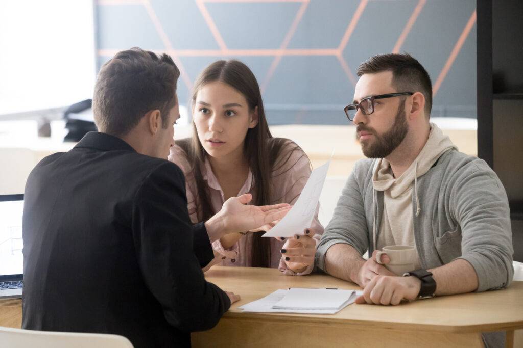 Angry millennial couple complaining about bad contract disputing with lawyer